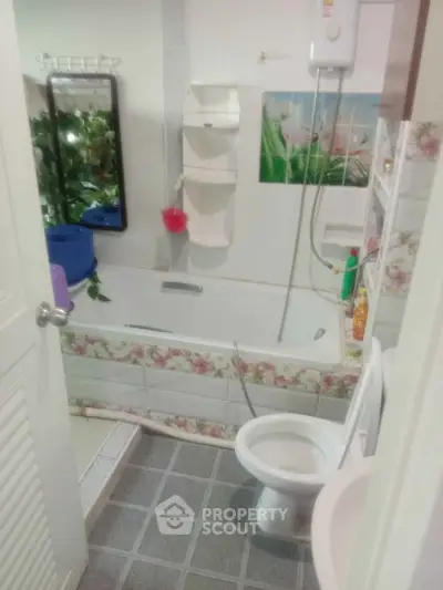 Cozy bathroom with floral tile accents and bathtub, perfect for relaxation.