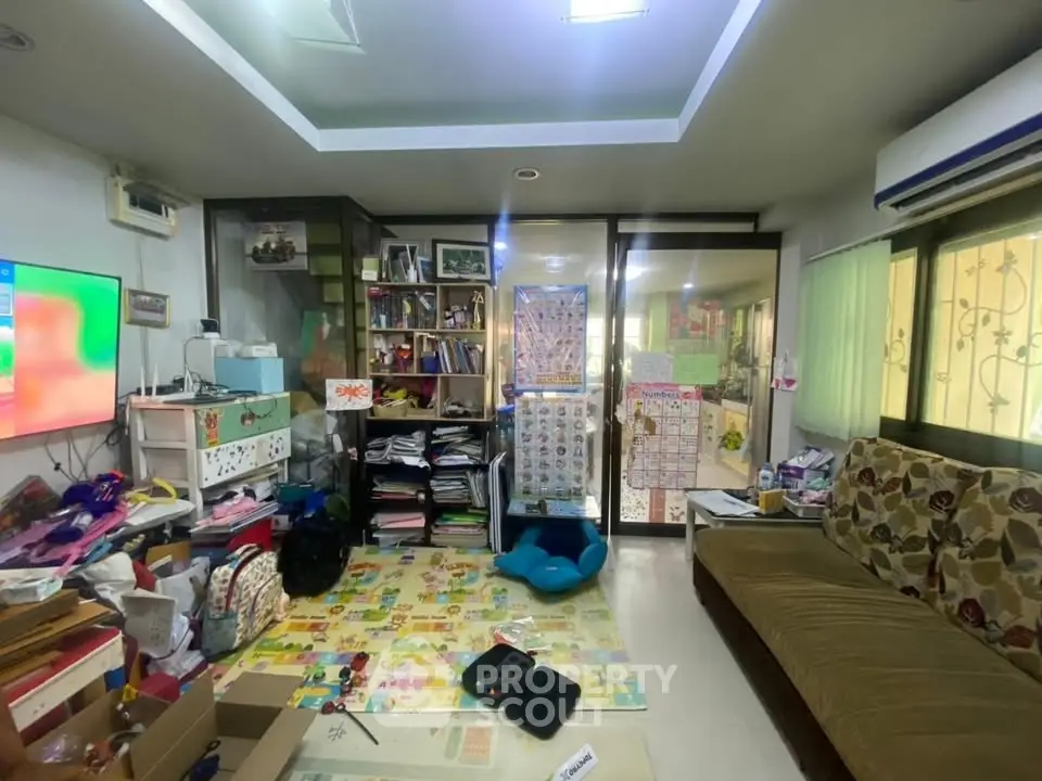 Spacious living room with colorful decor and ample storage space, perfect for family gatherings.