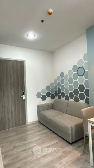Modern living room with stylish hexagonal wall design and cozy sofa.