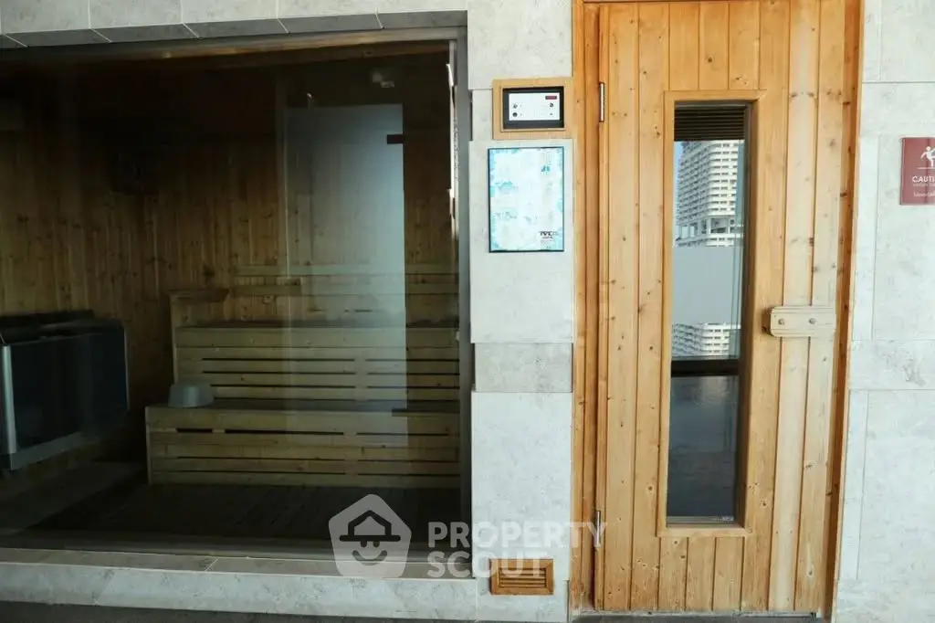 Luxurious sauna room with wooden interior and glass door in modern building.