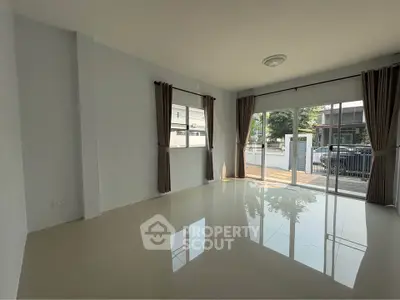 Spacious living room with large windows and glossy tiled floor in modern home