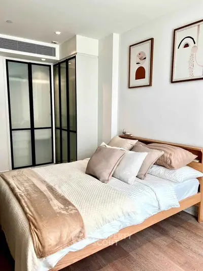Modern bedroom with stylish decor and sliding glass closet doors in a cozy apartment.