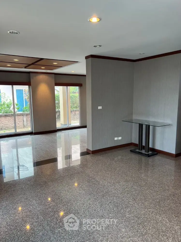 Spacious modern living room with glossy tile flooring and large windows