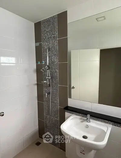 Modern bathroom with sleek shower and sink in contemporary design.