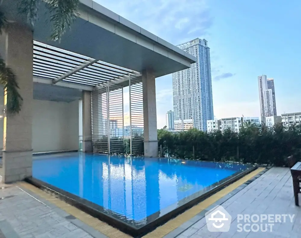 Luxurious rooftop pool with stunning city skyline views in modern high-rise building.