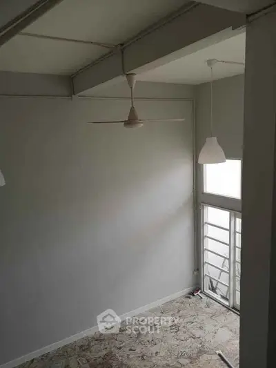 Spacious room with high ceiling and large window for natural light