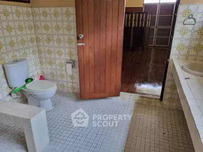 Vintage bathroom with retro tiles and wooden door, showcasing classic design elements.