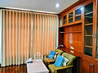 Cozy living room with wooden furniture and large curtains, perfect for relaxation.