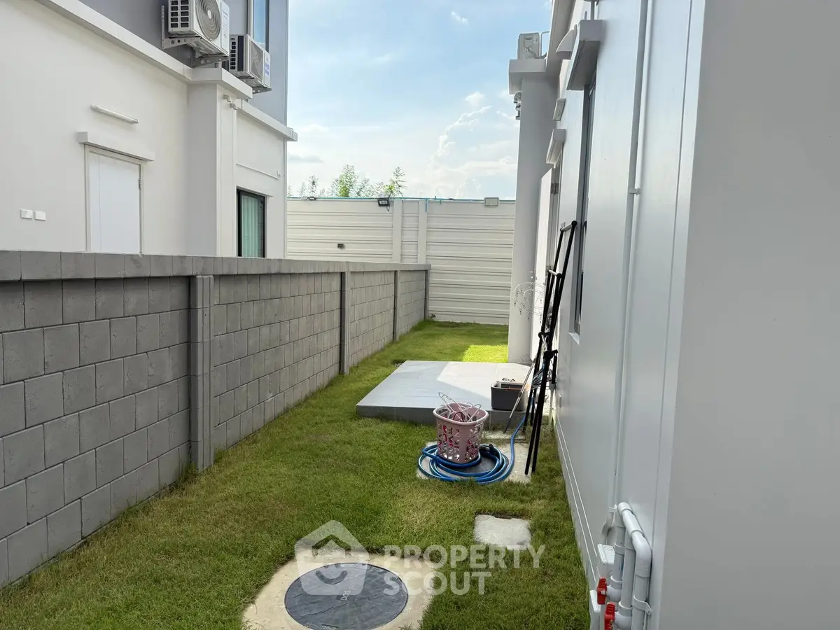 Modern residential side yard with grass and concrete path
