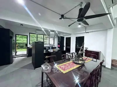 Spacious modern kitchen with dining area and ceiling fan, featuring sleek black cabinetry and large windows.