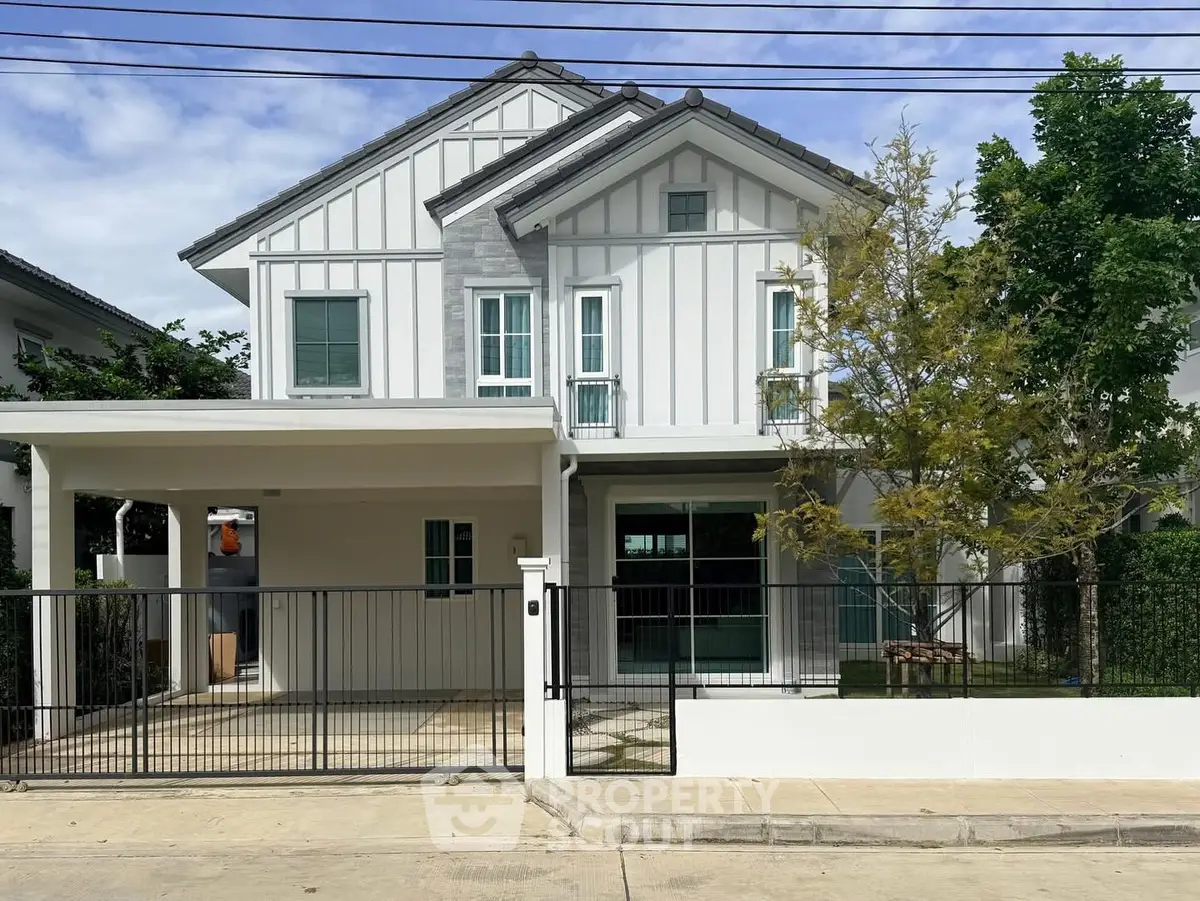Charming two-story house with modern facade and spacious driveway in a serene neighborhood.