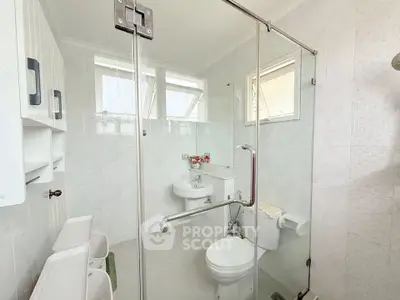 Bright and modern bathroom with glass shower and white fixtures