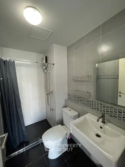 Modern bathroom with sleek fixtures and tiled walls in a contemporary apartment.