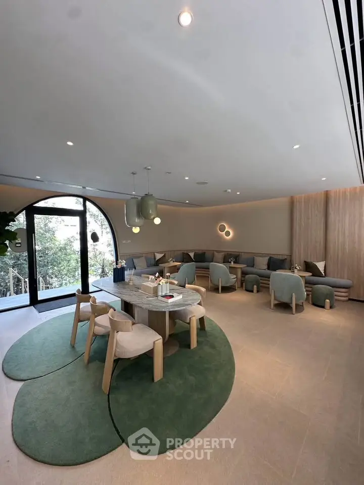 Luxurious modern living room with elegant furniture and large windows offering serene garden views.