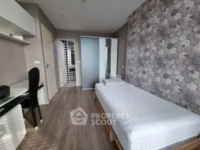 Modern bedroom with stylish decor and workspace in a contemporary apartment.