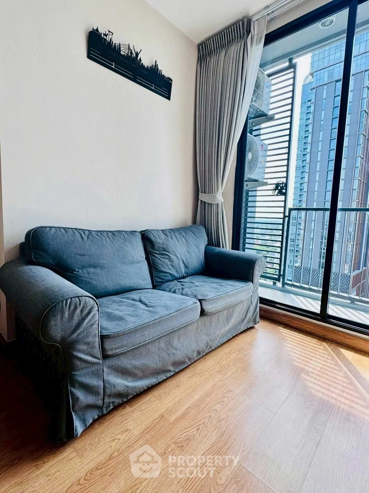 Cozy living room with blue sofa and city view balcony in modern apartment