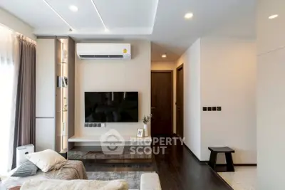 Modern living room with sleek design, featuring a wall-mounted TV and air conditioning unit.