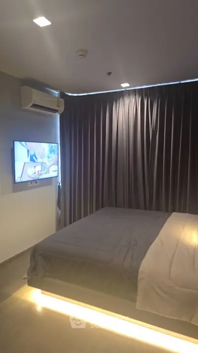 Modern bedroom with ambient lighting and wall-mounted TV