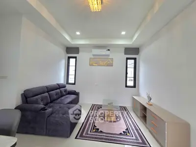 Modern living room with plush sofa, stylish decor, and ample natural light.