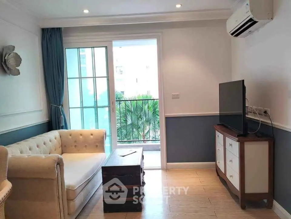 Charming living room with elegant decor and balcony view, featuring cozy seating and modern amenities.