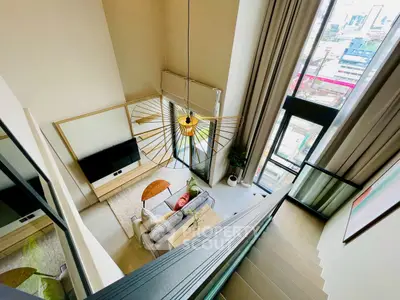 Stunning modern living room with high ceilings and large windows offering city views.