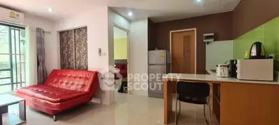 Modern open-layout living room with red sofa and kitchen appliances