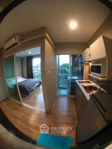 Modern compact apartment with open kitchen and cozy bedroom, featuring a balcony with a view.