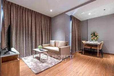 Modern living room with cozy seating and elegant dining area, featuring stylish decor and warm lighting.
