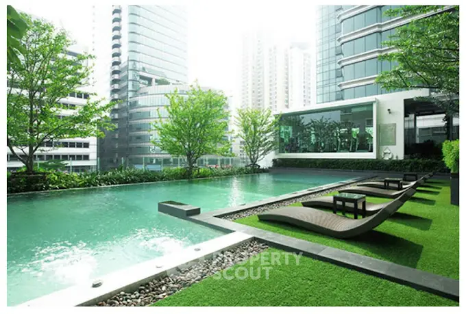 Luxurious urban pool with modern loungers and lush greenery, surrounded by skyscrapers.