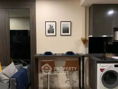 Modern kitchen with breakfast bar and washing machine in stylish apartment