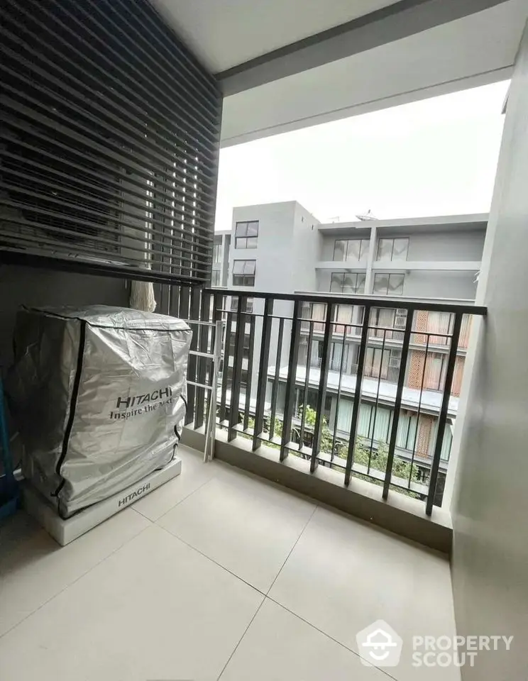 Modern balcony with sleek railing and outdoor unit in urban apartment.