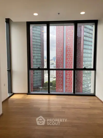 Spacious modern apartment with floor-to-ceiling windows and city view.