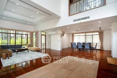 Spacious open-plan living and dining area with hardwood floors and large windows.