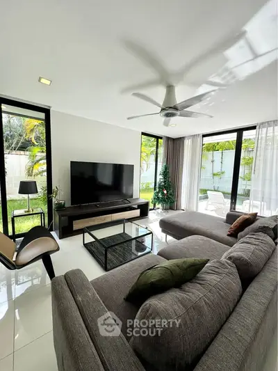 Spacious living room with modern decor and garden view, perfect for relaxation and entertainment.
