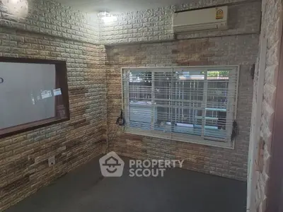 Cozy room with brick walls and air conditioning, perfect for a home office or study.