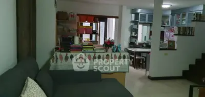 Cozy living room with modern kitchen in open layout, featuring stylish decor and comfortable seating.