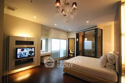 Luxurious modern bedroom with elegant chandelier and built-in TV, showcasing contemporary design.