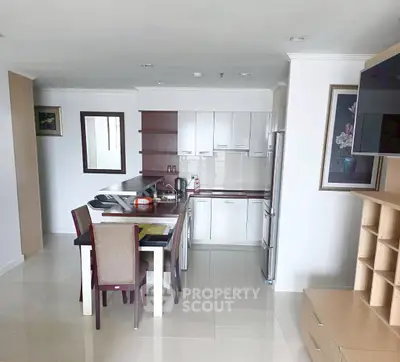 Modern kitchen with dining area and sleek cabinetry in open layout apartment.