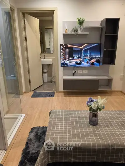 Modern living room with wall-mounted TV and stylish decor in a cozy apartment setting.