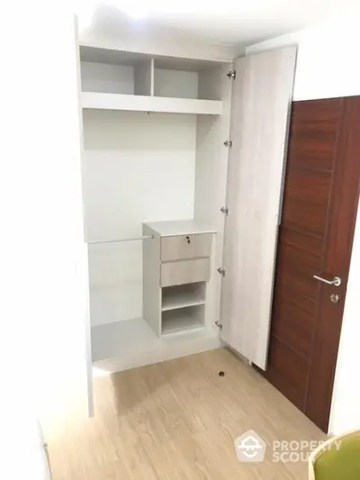 Spacious walk-in closet with modern wooden finish and ample storage space.