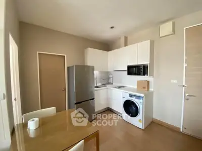 Modern kitchen with washing machine and fridge in compact apartment