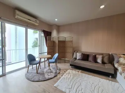 Modern living room with cozy seating and balcony view