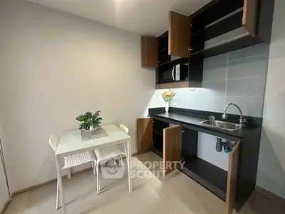 Modern kitchen with open cabinets and dining area in sleek apartment