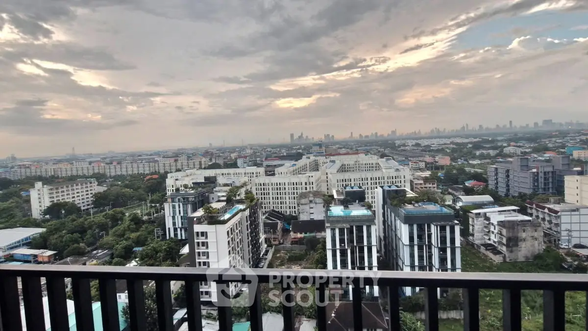 Stunning cityscape view from a high-rise balcony showcasing urban skyline and lush greenery.