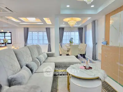 Luxurious living room with elegant decor and spacious dining area, featuring plush seating and modern lighting.