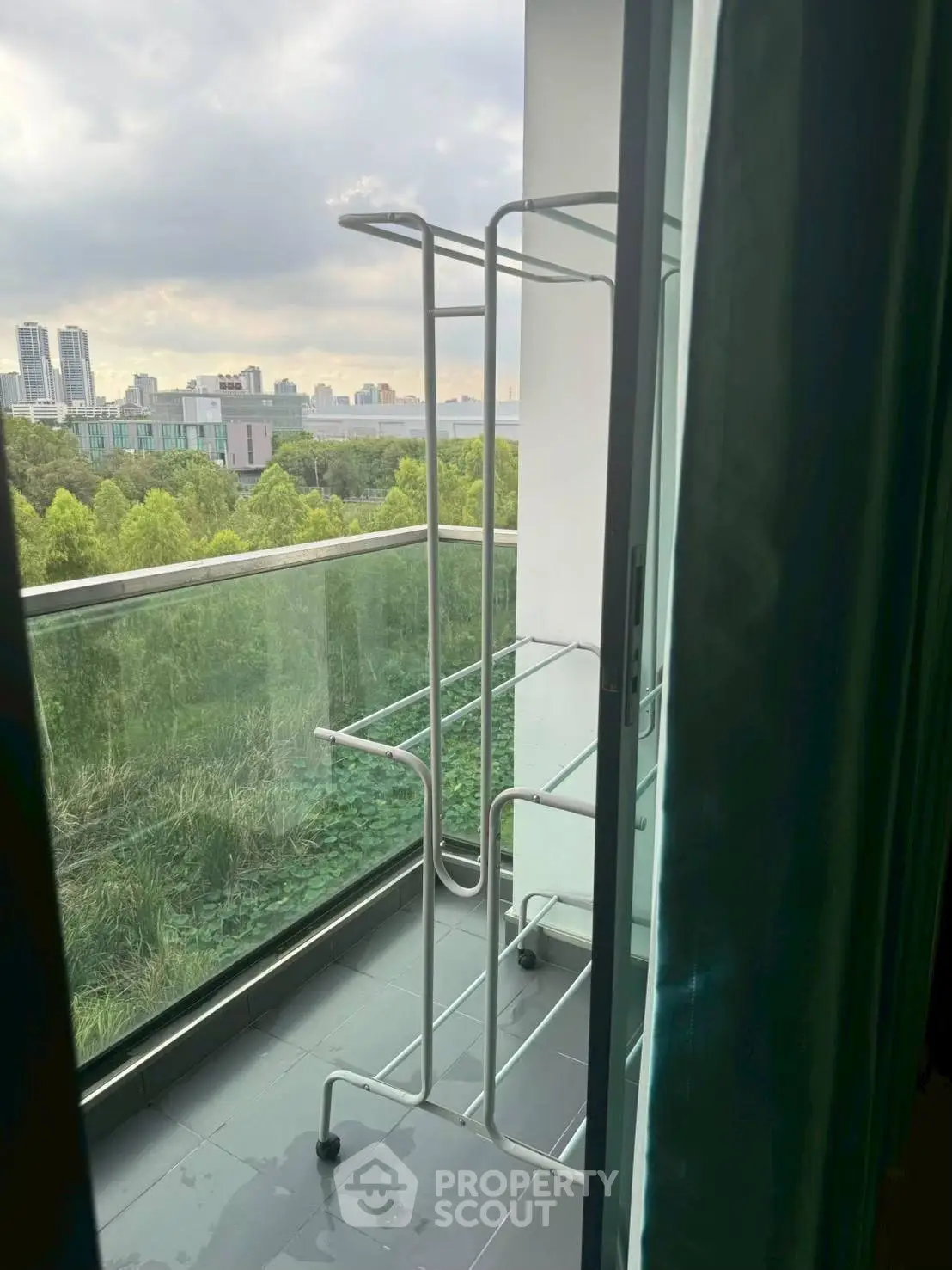 Modern balcony with city view and clothes drying rack, perfect for urban living.