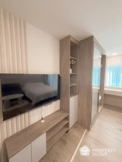 Modern bedroom with sleek wooden furniture and wall-mounted TV