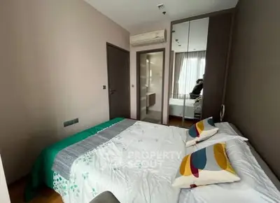 Cozy bedroom with modern decor and mirrored wardrobe in stylish apartment.