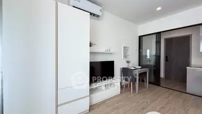 Modern living room with sleek furniture and dining area in a stylish apartment.