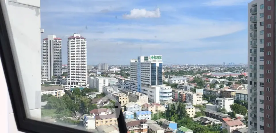 Stunning cityscape view from high-rise apartment window showcasing urban skyline and blue sky.